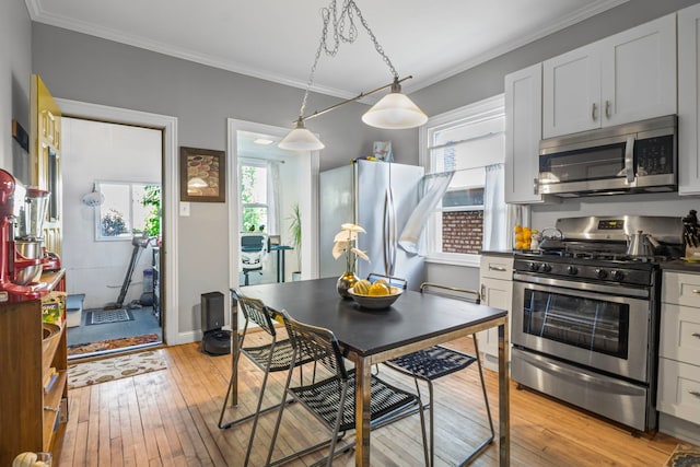 2119 N Karlov Ave, Chicago, IL 60639 - kitchen with appliances with stainless steel finishes, light wood-style floors, plenty of natural light, crown molding, and dark countertops