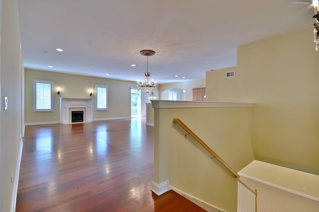 121 Rose Dr, Bloomingdale, IL 60108 - unfurnished living room featuring dark wood-style floors, a fireplace, recessed lighting, and a chandelier