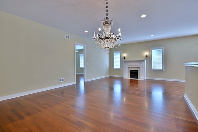 121 Rose Dr, Bloomingdale, IL 60108 - unfurnished living room with a chandelier, dark wood-type flooring, recessed lighting, and a fireplace