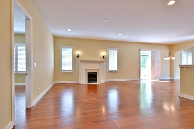 121 Rose Dr, Bloomingdale, IL 60108 - unfurnished living room featuring a fireplace with flush hearth, a chandelier, wood finished floors, and recessed lighting