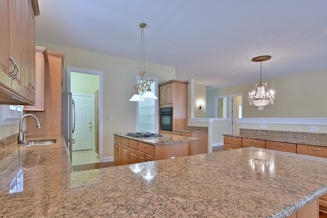 121 Rose Dr, Bloomingdale, IL 60108 - kitchen with appliances with stainless steel finishes, a kitchen island, light stone countertops, a chandelier, and decorative light fixtures