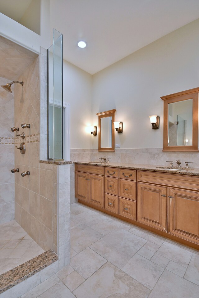 121 Rose Dr, Bloomingdale, IL 60108 - bathroom with tile walls, a tile shower, double vanity, and a wainscoted wall