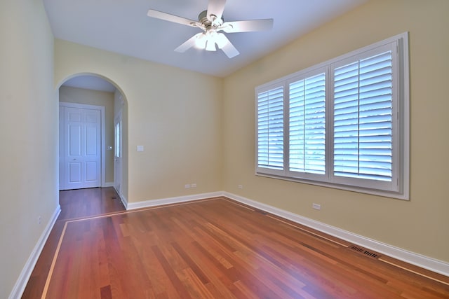 121 Rose Dr, Bloomingdale, IL 60108 - spare room featuring arched walkways, wood finished floors, and a ceiling fan