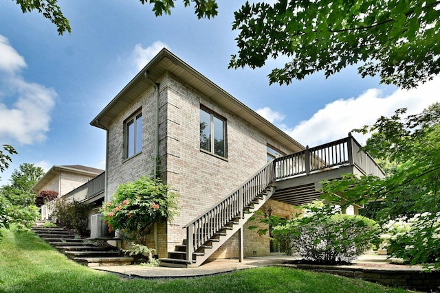 121 Rose Dr, Bloomingdale, IL 60108 - view of side of property featuring stairs, brick siding, a wooden deck, and a lawn