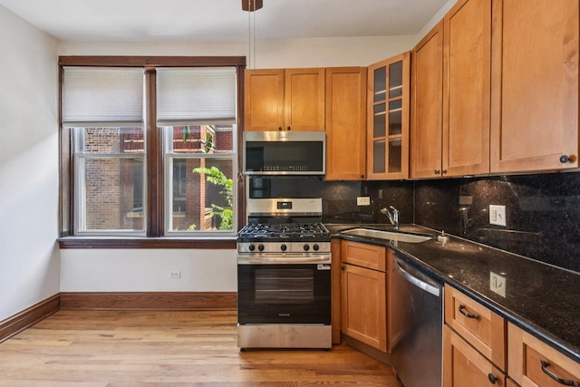 2638 W Rice St Unit 2S, Chicago, IL 60622 - kitchen featuring appliances with stainless steel finishes, light wood-type flooring, tasteful backsplash, dark stone countertops, and brown cabinets