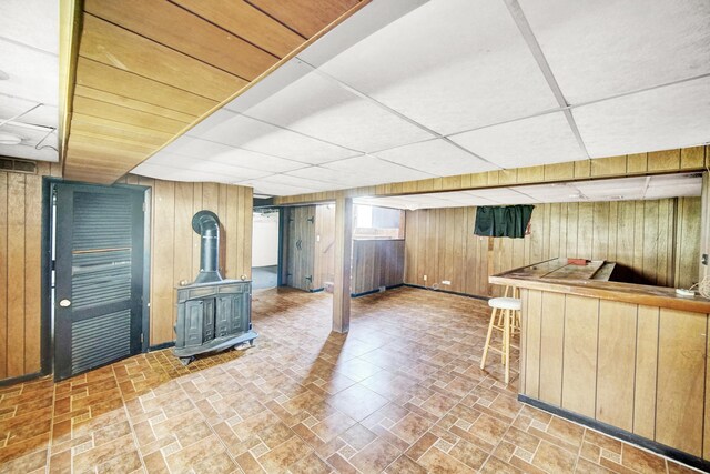 14528 Grant St, Dolton, IL 60419 - indoor dry bar featuring wooden walls, a drop ceiling, a wood stove, and brick patterned flooring