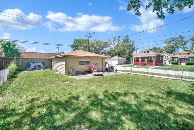 14528 Grant St, Dolton, IL 60419 - rear view of house with an outbuilding, a fenced backyard, a garage, and an outdoor fire pit