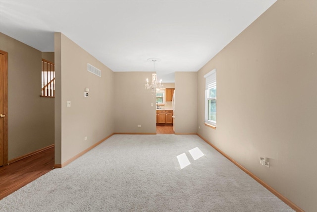 179 Briarcliff Ct, Romeoville, IL 60446 - spare room featuring a chandelier, light carpet, and stairway