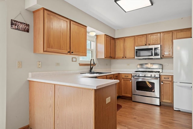 179 Briarcliff Ct, Romeoville, IL 60446 - kitchen featuring stainless steel appliances, a peninsula, light countertops, and light wood finished floors