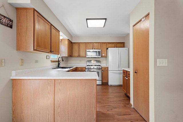 179 Briarcliff Ct, Romeoville, IL 60446 - kitchen with white appliances, wood finished floors, a peninsula, light countertops, and brown cabinetry