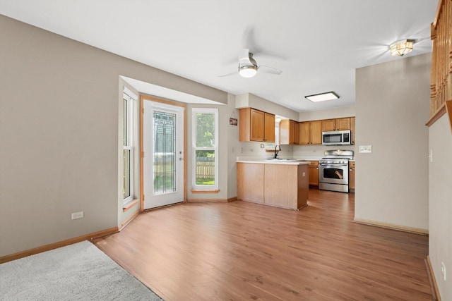 179 Briarcliff Ct, Romeoville, IL 60446 - kitchen with stainless steel appliances, a ceiling fan, light countertops, light wood finished floors, and a peninsula
