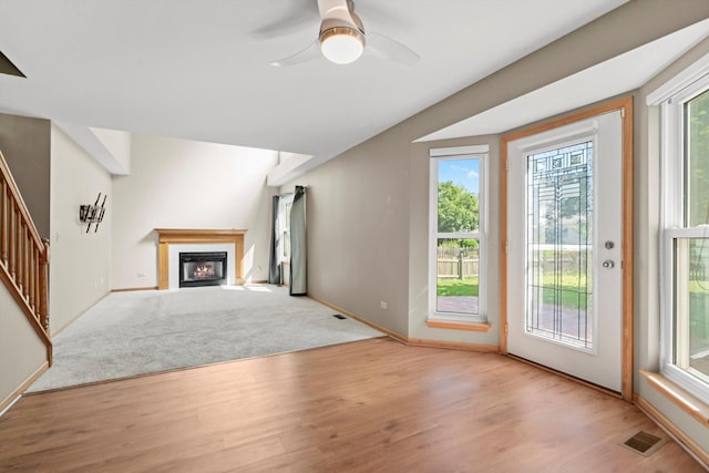 179 Briarcliff Ct, Romeoville, IL 60446 - unfurnished living room with wood finished floors, stairs, a fireplace with flush hearth, and ceiling fan