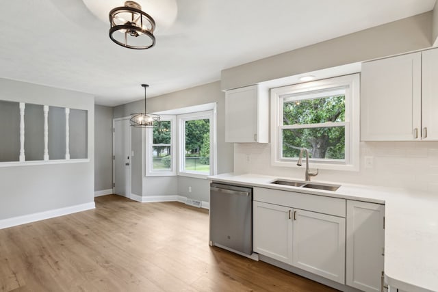 6282 Schaumburg Ln, Roscoe, IL 61073 - kitchen with stainless steel dishwasher, a chandelier, decorative backsplash, and light countertops