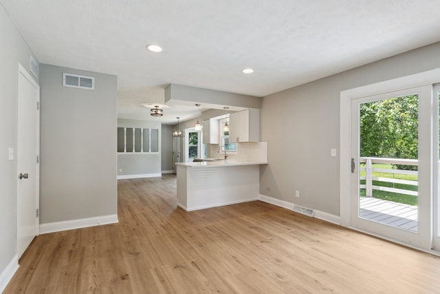 6282 Schaumburg Ln, Roscoe, IL 61073 - kitchen featuring light wood-style flooring, white cabinets, a peninsula, light countertops, and recessed lighting