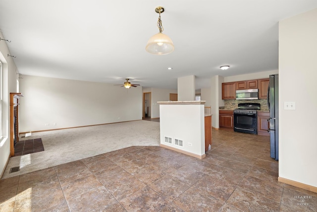 10961 Preston Pkwy, Huntley, IL 60142 - kitchen with black gas range, stainless steel microwave, freestanding refrigerator, carpet floors, and brown cabinets