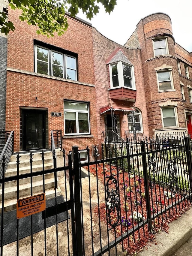 4409 S Prairie Ave, Chicago, IL 60653 - view of front facade featuring a fenced front yard and brick siding