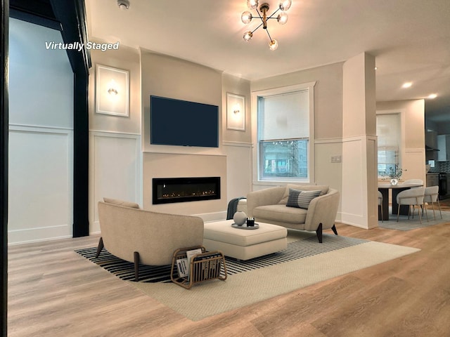 4409 S Prairie Ave, Chicago, IL 60653 - living room featuring a decorative wall, wood finished floors, a glass covered fireplace, wainscoting, and recessed lighting