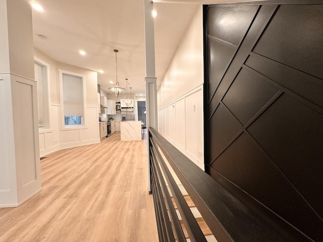 4409 S Prairie Ave, Chicago, IL 60653 - hallway with a decorative wall, light wood-style flooring, a chandelier, and recessed lighting