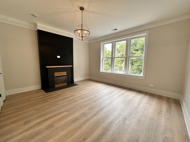 4409 S Prairie Ave, Chicago, IL 60653 - unfurnished living room with crown molding, light wood-style floors, a chandelier, and a fireplace