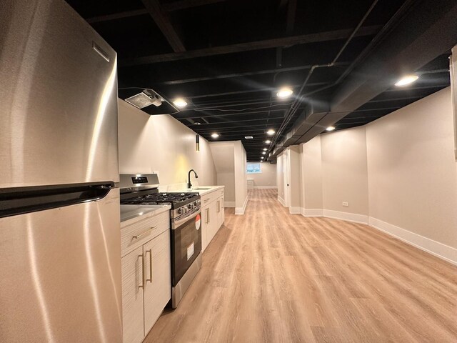 4409 S Prairie Ave, Chicago, IL 60653 - kitchen with appliances with stainless steel finishes, light wood-style flooring, light countertops, white cabinets, and ventilation hood
