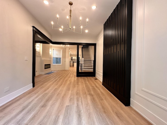 4409 S Prairie Ave, Chicago, IL 60653 - unfurnished room featuring a chandelier, light wood-style floors, stairway, and recessed lighting