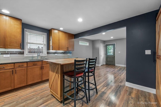 206 N Broadview Ave, Lombard, IL 60148 - kitchen with decorative backsplash, a kitchen breakfast bar, light wood finished floors, brown cabinets, and recessed lighting
