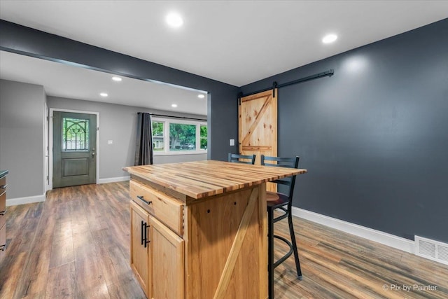 206 N Broadview Ave, Lombard, IL 60148 - kitchen with butcher block countertops, a barn door, dark wood-style floors, recessed lighting, and a kitchen bar