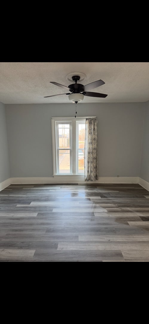 211 E Mulberry St, Bloomington, IL 61701 - empty room featuring a textured ceiling, wood finished floors, and ceiling fan