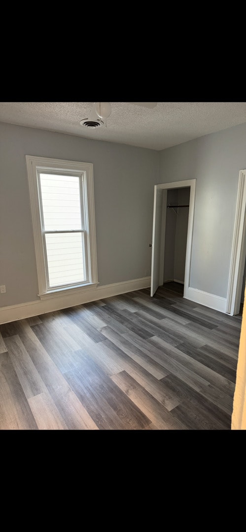 211 E Mulberry St, Bloomington, IL 61701 - unfurnished bedroom with wood finished floors and a closet
