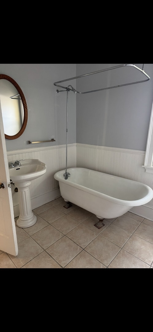 211 E Mulberry St, Bloomington, IL 61701 - bathroom with wainscoting, a soaking tub, and tile patterned flooring