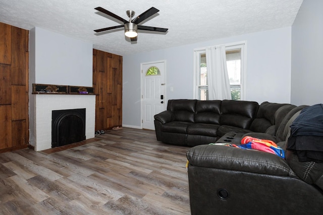 211 E Mulberry St, Bloomington, IL 61701 - living area with a textured ceiling, a ceiling fan, wood finished floors, and a brick fireplace