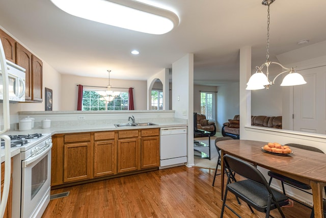 32374 N Allegheny Way Unit 0, Lakemoor, IL 60051 - kitchen featuring white appliances, a chandelier, brown cabinets, light countertops, and wood finished floors