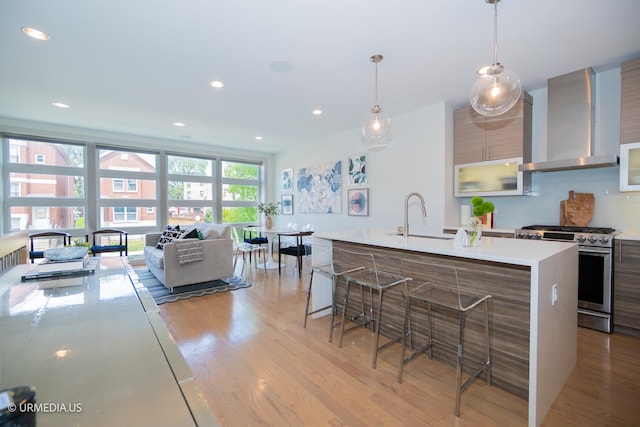 1221 E 46th St Unit 1, Chicago, IL 60653 - kitchen with stainless steel range with gas stovetop, wall chimney exhaust hood, modern cabinets, light countertops, and decorative backsplash
