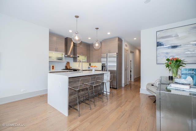 1221 E 46th St Unit 1, Chicago, IL 60653 - kitchen featuring wall chimney exhaust hood, stainless steel refrigerator with ice dispenser, modern cabinets, a kitchen bar, and recessed lighting