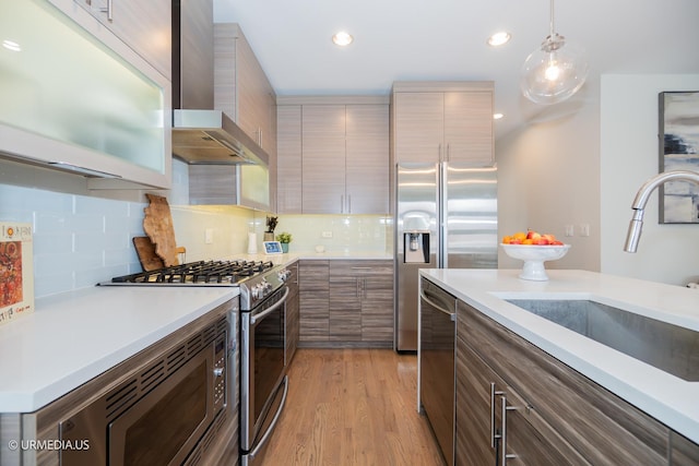 1221 E 46th St Unit 1, Chicago, IL 60653 - kitchen with appliances with stainless steel finishes, wall chimney range hood, light countertops, hanging light fixtures, and recessed lighting