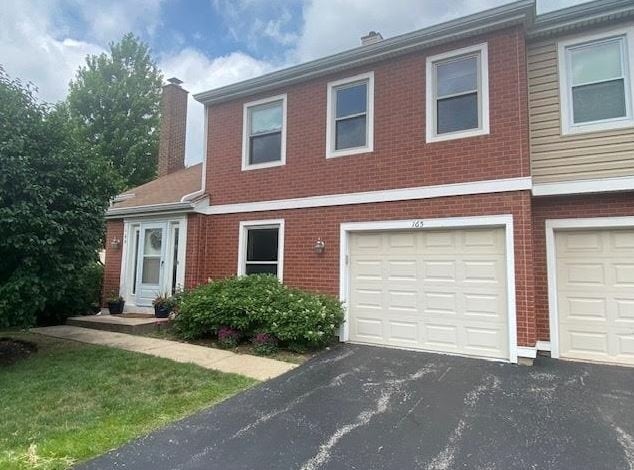 165 S Stonington Dr, Palatine, IL 60074 - view of front of house with a chimney, brick siding, and asphalt driveway