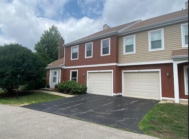 165 S Stonington Dr, Palatine, IL 60074 - view of property featuring a chimney, driveway, a garage, and brick siding