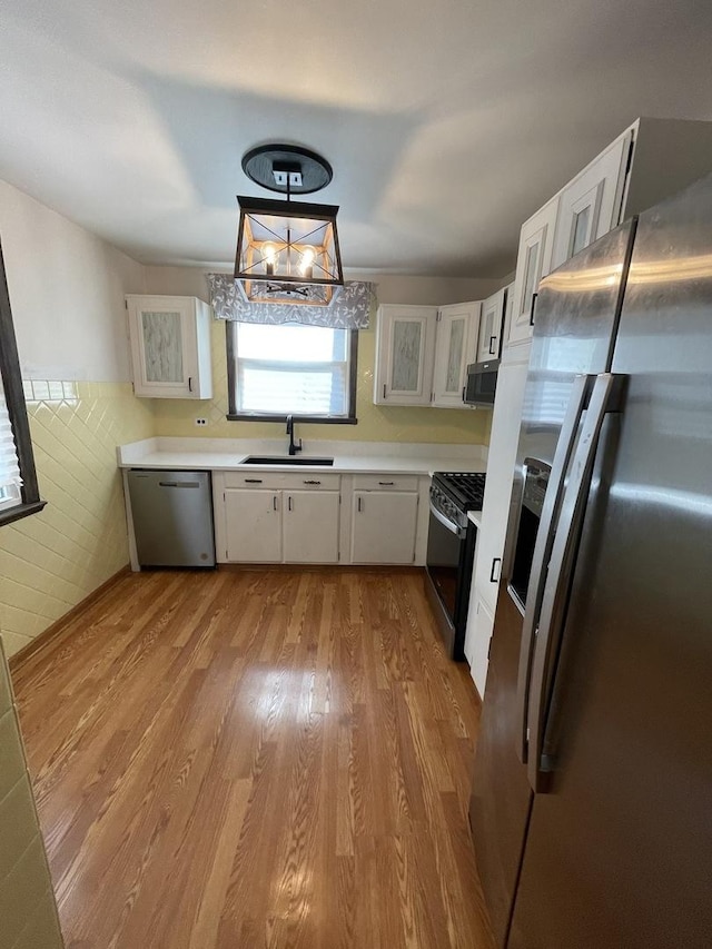 12813 E Playfield Dr, Crestwood, IL 60418 - kitchen featuring appliances with stainless steel finishes, wood finished floors, white cabinets, light countertops, and wainscoting