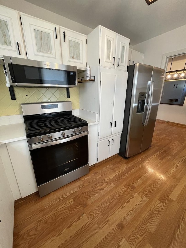 12813 E Playfield Dr, Crestwood, IL 60418 - kitchen featuring stainless steel appliances, light wood finished floors, light countertops, white cabinetry, and tasteful backsplash
