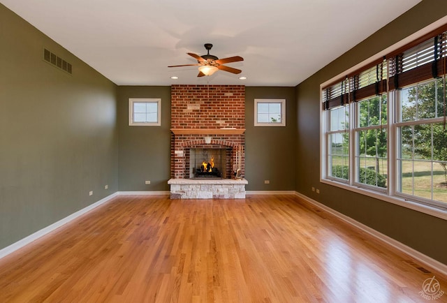 1019 Freedom Cir, Sycamore, IL 60178 - unfurnished living room with ceiling fan, light wood-type flooring, a brick fireplace, and recessed lighting