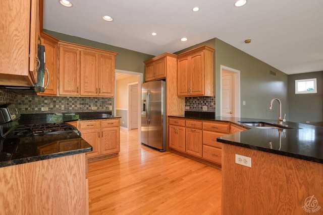 1019 Freedom Cir, Sycamore, IL 60178 - kitchen featuring appliances with stainless steel finishes, light wood-style floors, recessed lighting, decorative backsplash, and dark stone counters