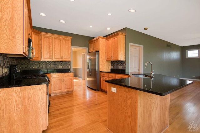1019 Freedom Cir, Sycamore, IL 60178 - kitchen with stainless steel appliances, light wood-style flooring, a peninsula, backsplash, and recessed lighting