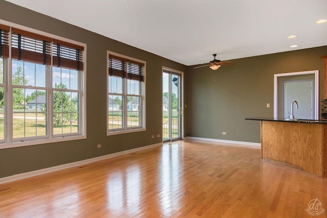 1019 Freedom Cir, Sycamore, IL 60178 - unfurnished living room featuring a ceiling fan and light wood-style flooring