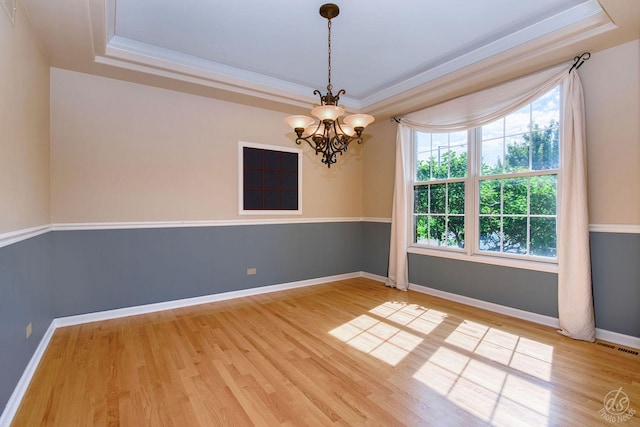 1019 Freedom Cir, Sycamore, IL 60178 - empty room featuring a tray ceiling, plenty of natural light, light wood finished floors, a chandelier, and ornamental molding