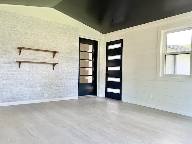 909 N Brinton Ave, Dixon, IL 61021 - foyer entrance with vaulted ceiling, brick wall, and wood finished floors