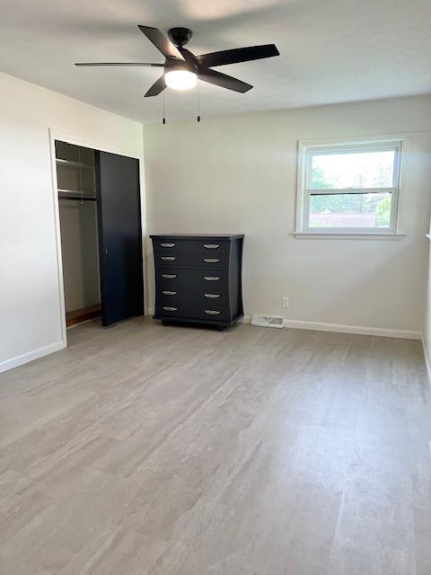 909 N Brinton Ave, Dixon, IL 61021 - unfurnished bedroom featuring a closet, ceiling fan, and light wood-type flooring