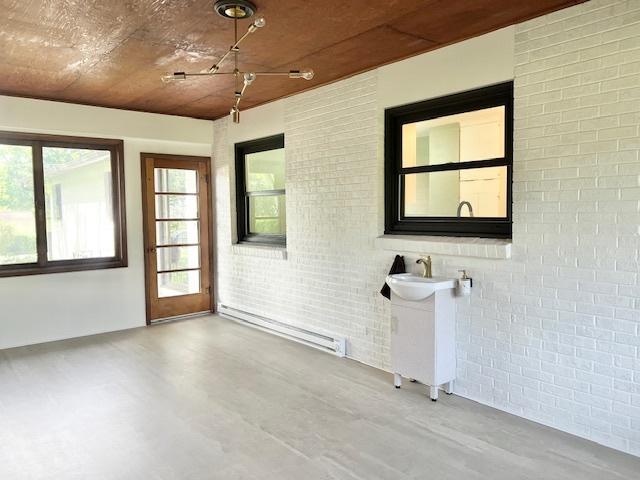 909 N Brinton Ave, Dixon, IL 61021 - unfurnished sunroom with baseboard heating and a sink