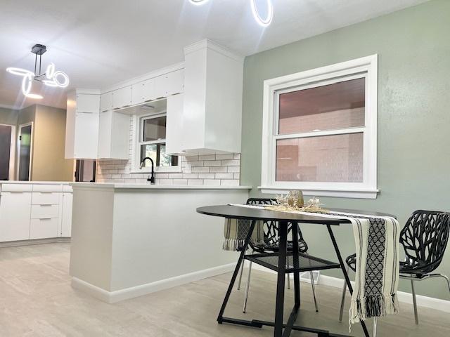 909 N Brinton Ave, Dixon, IL 61021 - kitchen with white cabinets, decorative backsplash, decorative light fixtures, and light countertops