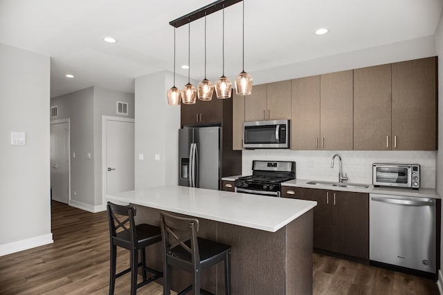 2304 W Jackson Blvd Unit 2W, Chicago, IL 60612 - kitchen with stainless steel appliances, dark wood-style flooring, light countertops, a breakfast bar area, and recessed lighting