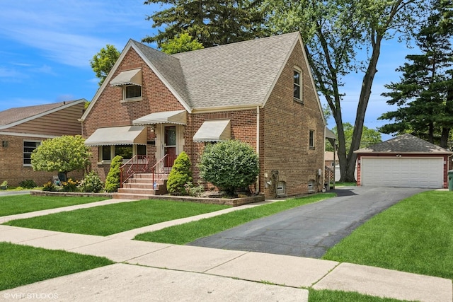 9326 S Millard Ave, Evergreen Park, IL 60805 - tudor house featuring roof with shingles, brick siding, a detached garage, a front yard, and an outbuilding